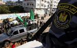 Folk samles om en lastbil fra Hamas’ sikkerhedsstyrker efter den i går blev beskudt. I forgrunden ses et medlem af sikkerhedsstyrkerne. 