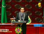 Turkmenistans nye præsident holder her sin første tale til Folkets Råd. Talen blev transmitteret på turkmensk tv. Bemærk det gyldne kontrafej i hjørnet. Det er den tidligere præsident og diktator Samurat Nijasovs portræt, der ifølge et dekret skal pryde ethvert tv-indslag i Turkmenistan. 
