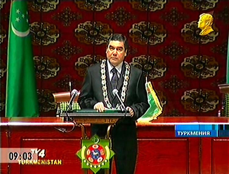 Turkmenistans nye præsident holder her sin første tale til Folkets Råd. Talen blev transmitteret på turkmensk tv. Bemærk det gyldne kontrafej i hjørnet. Det er den tidligere præsident og diktator Samurat Nijasovs portræt, der ifølge et dekret skal pryde ethvert tv-indslag i Turkmenistan. 