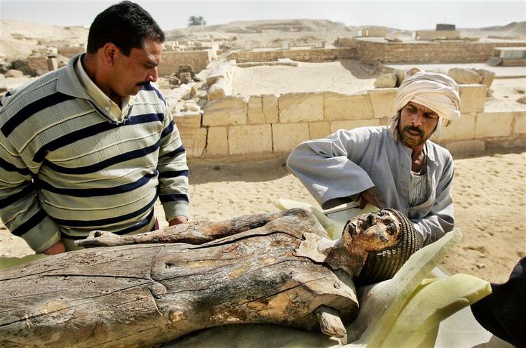 Arkæologer flytter en træstatue fra en mere end 4.000 år gammel grav, som har tilhørt en af faraoens skrivere og hans hustru. 