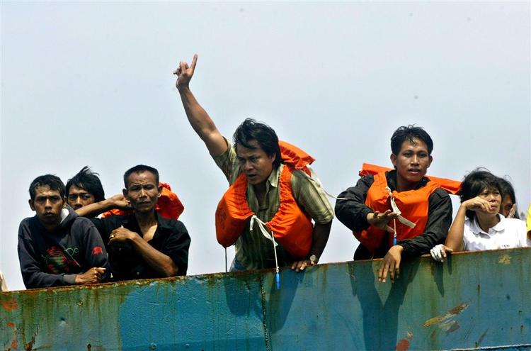 Overlevende fra skibsbranden i Indonesien føres i havn. 