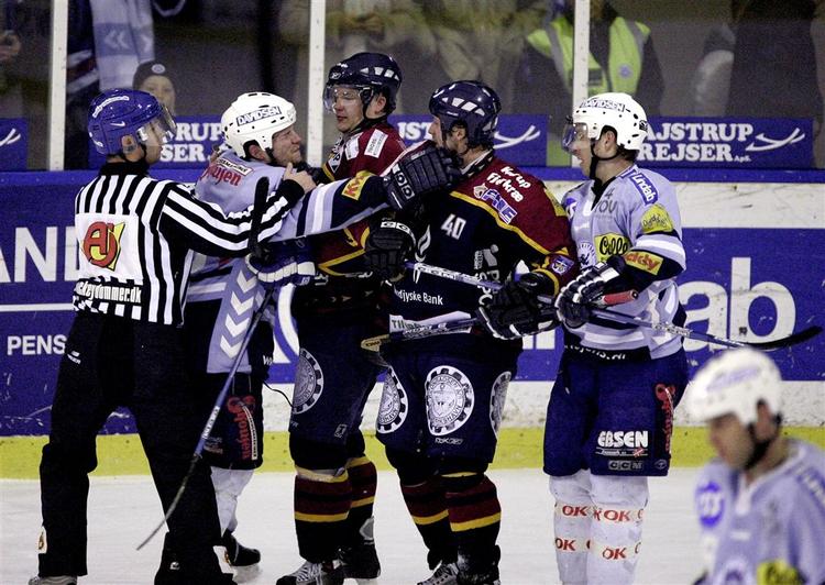 Sønderjyskes stjernespiller Brad Rooney(i lyseblåt til venstre i billedet) blev idømt fire to-minutters og en ti-minutters udvisning i kvartfinalen mod Rødovre. Her fra en tidligere kamp. 