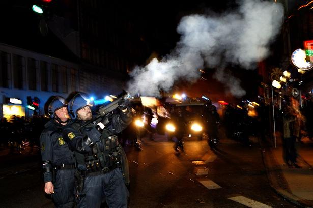 Tåregassen bølgede gennem gaderne, så både demonstranter og fredelige borgere måtte tage flugten. 