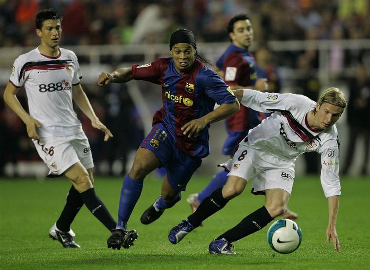 Christian Poulsen kæmper om bolden med Barcelonas Ronaldinho. 
