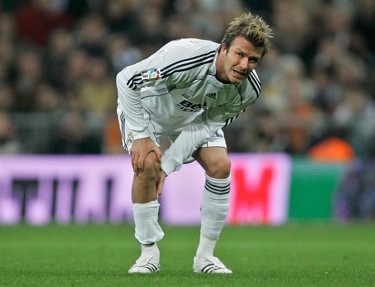 David Beckham tager sig til sit skadede højre knæ under kampen mod Getafe. 