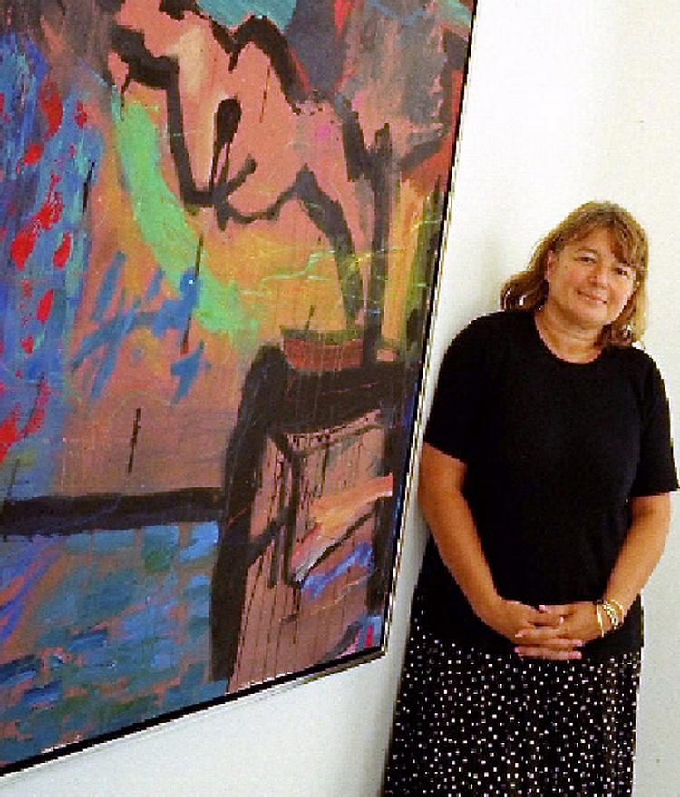 Patricia Asbæk på sit galleri ved siden af billede af kunstneren Jens Birkemose. 