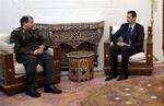 USA kræver handling fra Syriens præsident Bashar Assad (th), der her mødes med den iranske forsvarsminister under weekendens konference om Iraks fremtid. 