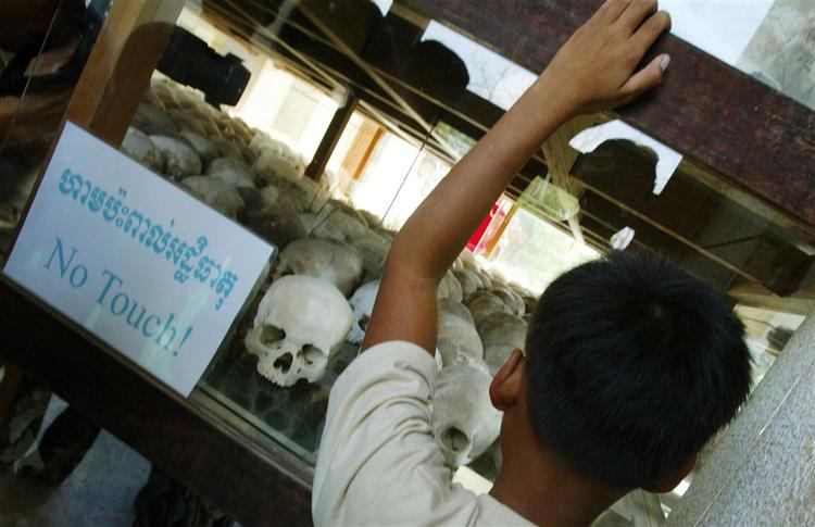 En cambodjansk dreng kigger kigger på kranier fra ofre for Røde Khmer-styrets brutalitet. 