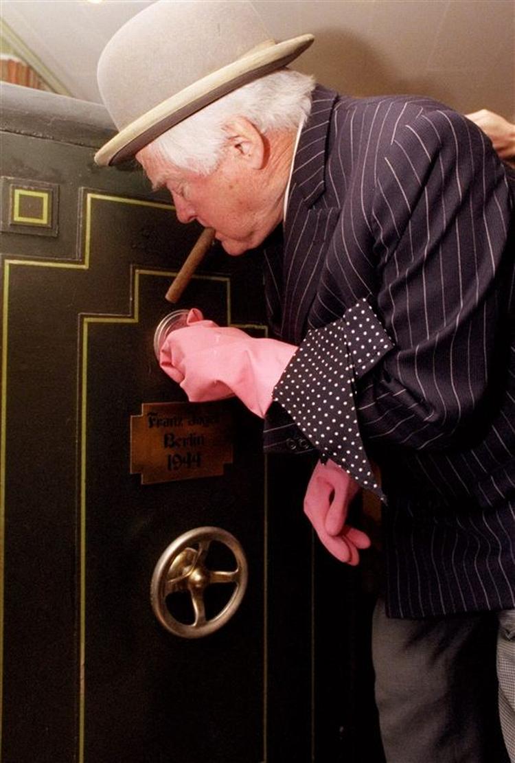 Efter stor succes med 14 Olsen Banden-film, skal Egon Olsen og hans kumpaner nu til at synge deres planer i en ny musical. her er dewt den originale Egon i skikkelse af Ove Sprogøe, som åbner et af sin karrieres utallige pengeskabe. 