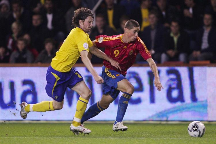 Fernando Torres (i rødt) i kamp med Sveriges Mikael Nilsson. Torres har scoret en gang i kvalifikationen, men kan ikke være sikker på en plads i den spanske startopstilling, hvor Valencia-duoen David Villa og Fernando Morientes også ønsker at få plads. 