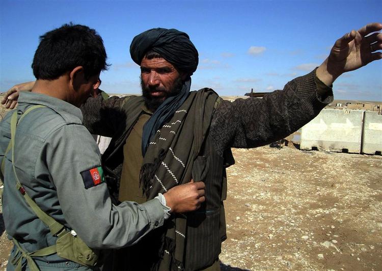 Afghansk politimand visiterer afghansk mand i Gereshk-distriktet i februar. 