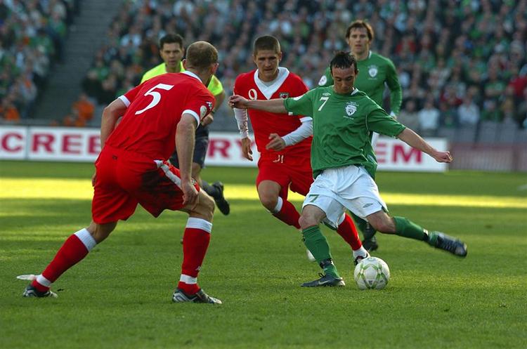 Stephen Ireland, th., snyder walisernes Steve Evans, inden han sender bolden i nettet til kampens slutresultat. 