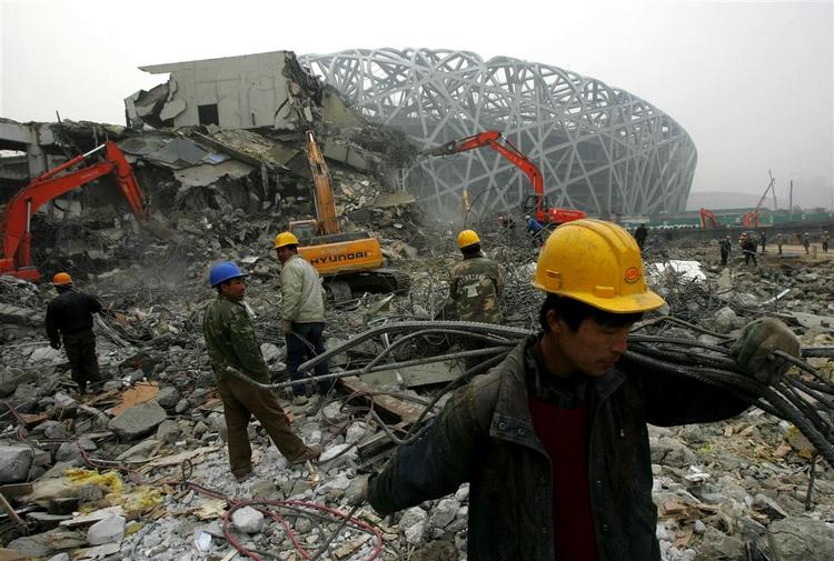 Overalt i Beijing er der travlt med at blive klar til De Olympiske Lege i 2008. Her bliver der fjernet stål fra nedbrydningsarbejdet foran hovedstadens nationale stadion, der skal huse åbningsceremonien i 2008. 
