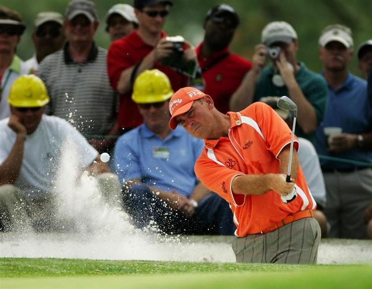 Et par tilskuere har taget deres forholdsregler, selv om det er verdens bedste der sender de hårde golfbolde af sted. Her er Thomas Bjørn på vej op fra bunkeren under onsdagens træningsrunde på Augusta National. 