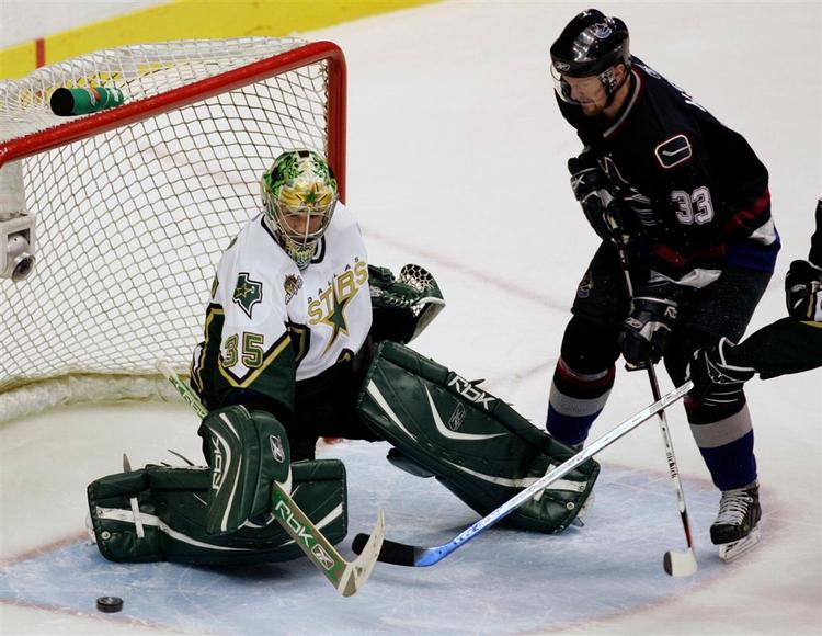 Vancouver Canucks' Henrik Sedin (33) bliver den lille i duel med Dallas-keeper Marty Turco i første periode af playoff-kampen. 