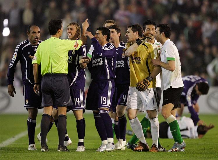 Real Madrid-spillere danner klynge foran dommeren under den dramatiske kamp i Santander. 