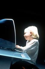 A young girl sitting at a desk using a computer.