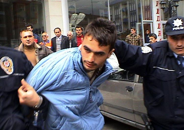 Tyrkisk politi trækker afsted med én af de fire attentatmænd foran forlaget i Malatya. 