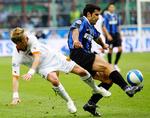 Romas svensker Wilhelmsson takler Inters portugisiske veteran Luis Figo. 