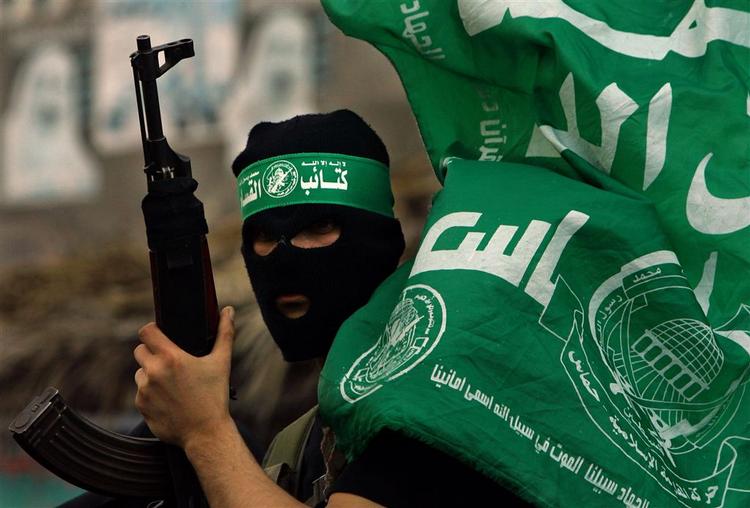 En militant Hamas-tilhænger viser sit våben frem i Gaza - dagen efter Hamas brød den fem måneder lange våbenhvile med et raketangreb ind i Israel. 