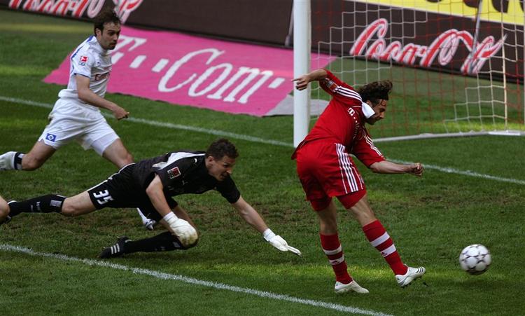 Claudio Pizarro bringer Bayern i front i dagens kamp, mens HSV-keeper Frank Rost spræller forgæves. 