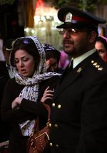 En iransk kvinde bliver anholdt af politiet for at bære sit tørklæde for løst. 