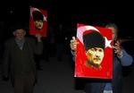 Demonstranter med billeder af det moderne, sekulæres Tyrkiets alfader, Kemal Atatürk. Regeringspartiets islamiske rødder har skabt debat i Tyrkiet. 