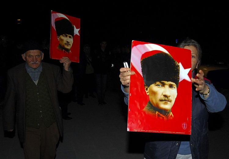 Demonstranter med billeder af det moderne, sekulæres Tyrkiets alfader, Kemal Atatürk. Regeringspartiets islamiske rødder har skabt debat i Tyrkiet. 