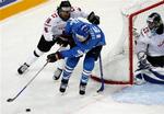 Finlands Tuomo Ruutu(i blåt) kæmper om pucken med Andres Ambuh(t.v.) og målmand Jonas Hiller fra Schweiz. 