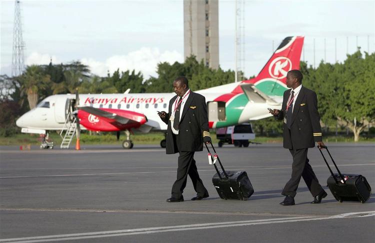 To piloter fra Kenay Airways går over landingsbanen i lufthavnen i Nairobi, hvor det forsvundne fly skulle være landet. 