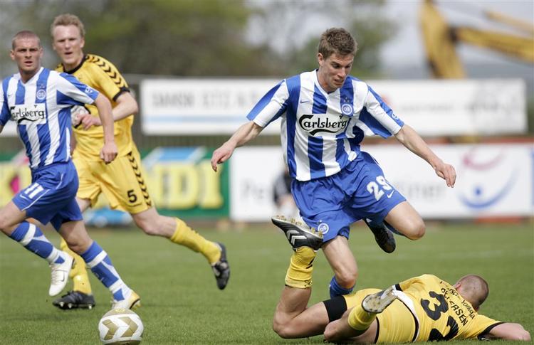 OB's Jonas Borring forcerer en liggende Horsens-spiller i kampen i dag. 