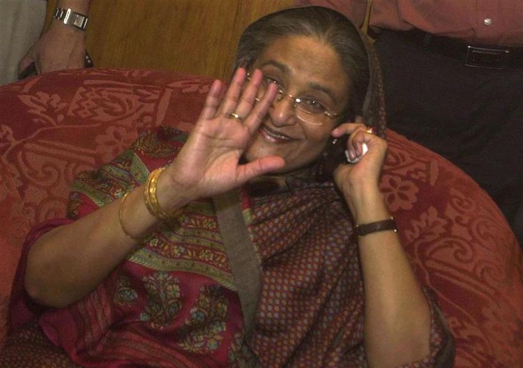 Sheikh Hasina vinker i lufthavnen ved hjemkomsten til Dhakas internationale lufthavn. 
