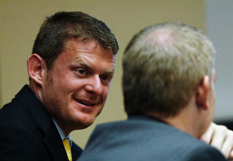 Den amerikanske cykelrytter Floyd Landis smiler til en af sine forsvarere, da dopingsagen blev åbnet i dag. 