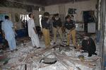 Pakistansk politi undersøger hotellet i Peshawar efter en bombe har slået mindst 24 mennesker ihjel. 