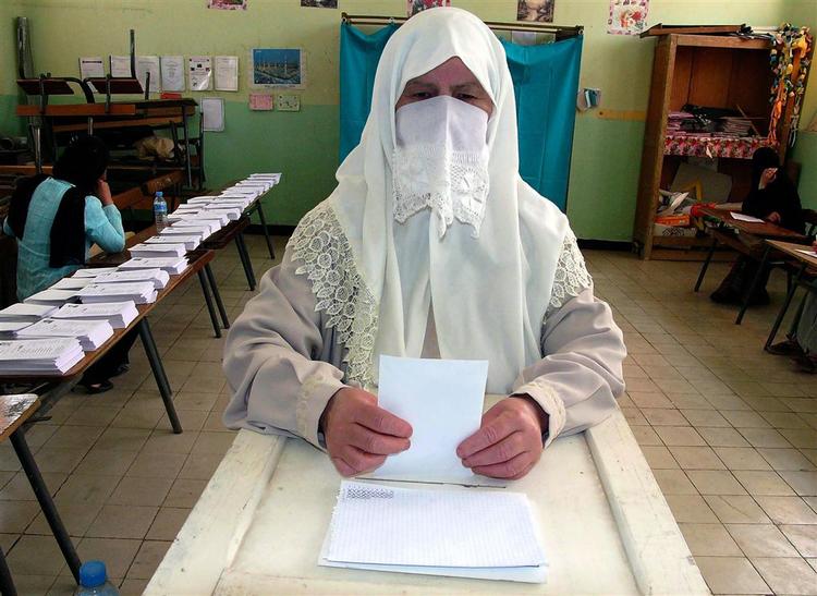 En algiersk kvinde afgiver sin stemme ved det valget i går. De præsidenttro pertier vandt. 