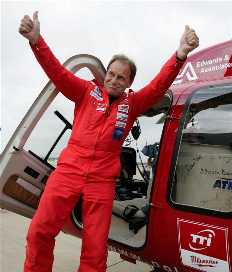 Den engelske pilot Colin Bodill jubler efter at have sat verdensrekord i sin røde helikopter. 