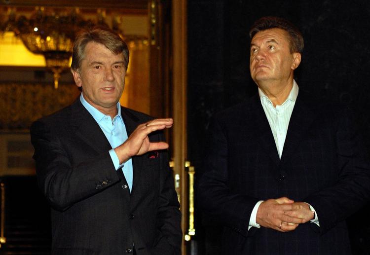 Den ukrainske premierminister Janukovitj ser på, mens præsident Jusjtjenko fremlgger  kompromisset for pressen. 