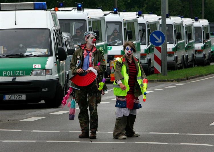 Politiet har 16.000 mand til at sørge for sikkerheden på topmødet. Her beskyttes et tidligere asylcenter, imens udklædte aktivister ser til. 