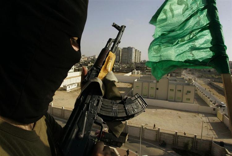 Hamas-tilhænger på taget af det palæstinensiske Efterretningshovedkvarter.Hamas væbnede styrker erklærede i går sejr i Gazastriben, selv om de rivaliserende Fatahstyrker stadig sidder på tre baser i området. 