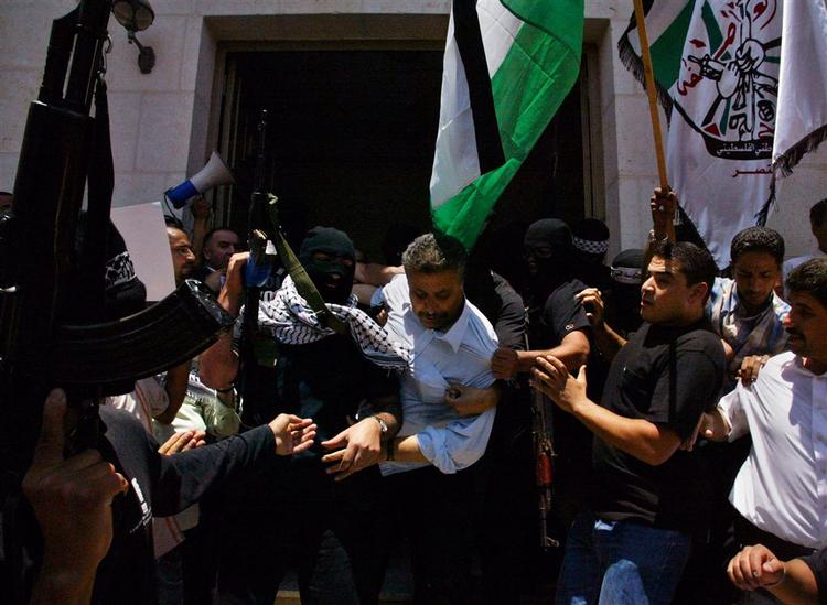 Militante Fatah-folk stormede i går parlamentsbygningen i Ramallah på Vestbredden og fører her Hamas-parlamentarikere væk fra bygningen. 