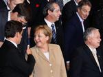 Den franske præsident Nicolas Sarkozy gestikulerer til den tyske kansler Angela Merkel under optagelsen af fotos til EU-familiealbummet. Ved siden af Merkel står den polske præsident Kaczynski. 