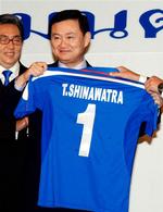 Thailands tidligere premierminister Thaksin Shinawatra med en trøje fra klubben Manchester City, som han forsøger at købe. 