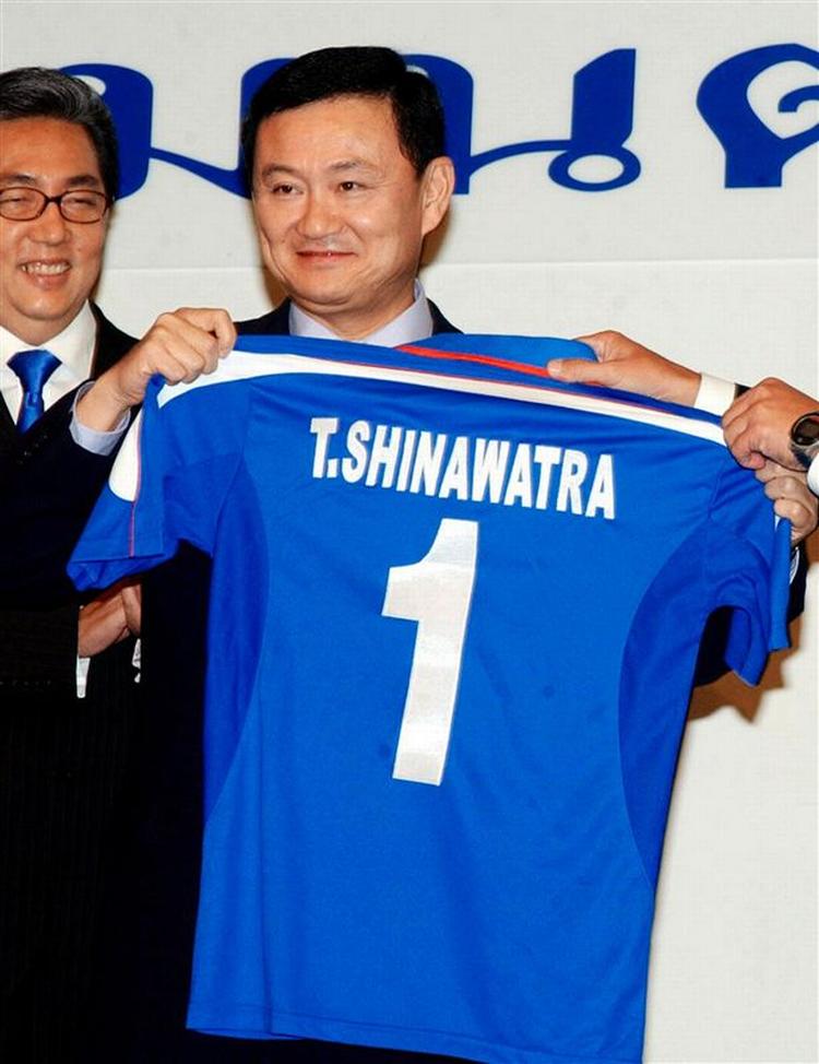 Thailands tidligere premierminister Thaksin Shinawatra med en trøje fra klubben Manchester City, som han forsøger at købe. 