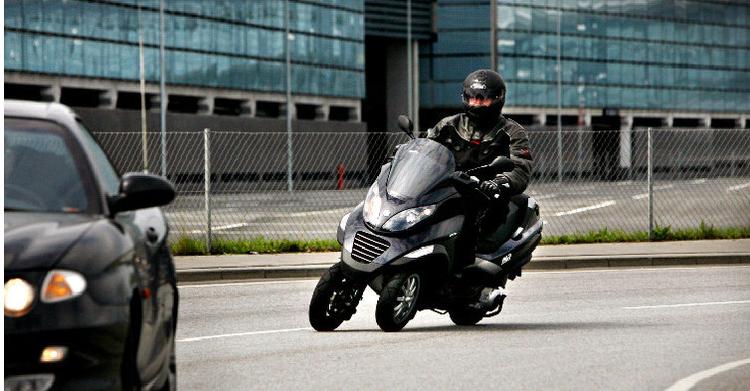Piaggio MP3 lægger sig fint til siden, når den kører sikkert gennem kurverne. 