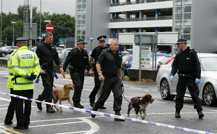 Politi med bombehunde på arbejde i lufthavnen i Glasgow. 