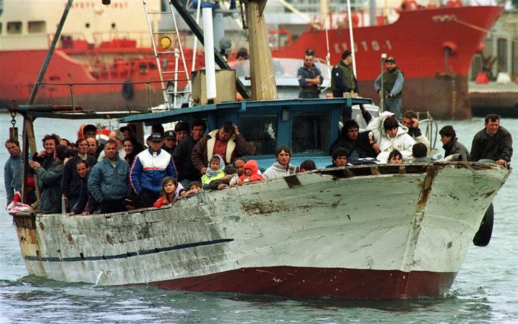 Omkring 100 albanske flygtninge på vej i havn i den italienske by Brindisi i marts. 