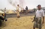 Yemenitter samlet ved vraget af de bomberamte biler. 