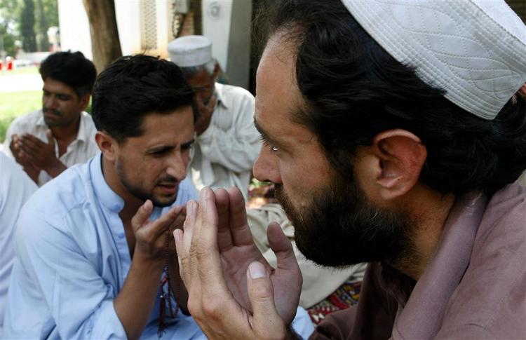 Familiemedlemmer til de mennesker, der er fanget i Den Røde Moske, beder for deres sikkerhed i Islamabad i dag. 