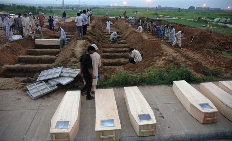 Pakistanske arbejdere i Islamabad graver grave til, de som blev dræbt ved regeringsstyrkernes angreb på Den Røde Moske. 