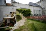 Til opsætningen af 'Glade dage' er der skabt en sindrig scenografi, hvor skuespilleren Kirsten Lehfeldt kan hejses op og ned i sin jordhøj. Til højre ses resterne af Odd Fellow Palæet, som blev bygget 1751-55 af gehejmeråd August von Berckentin. Fra 1889 rummede bygningen også en stor koncertsal. 